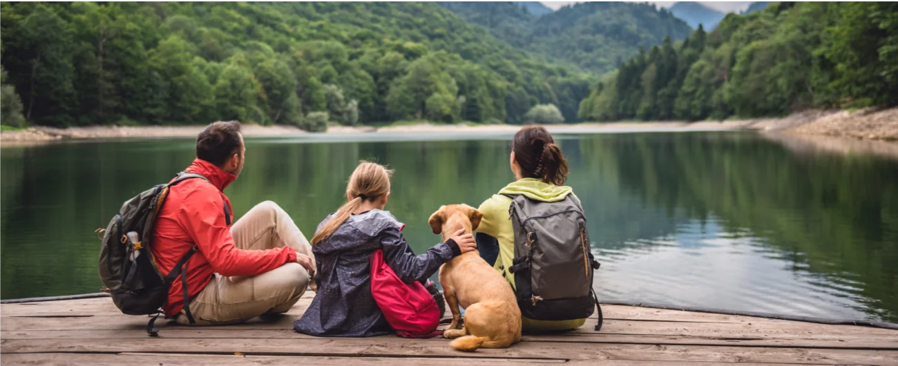 Family sitting with their dog beside a Massachusetts lake