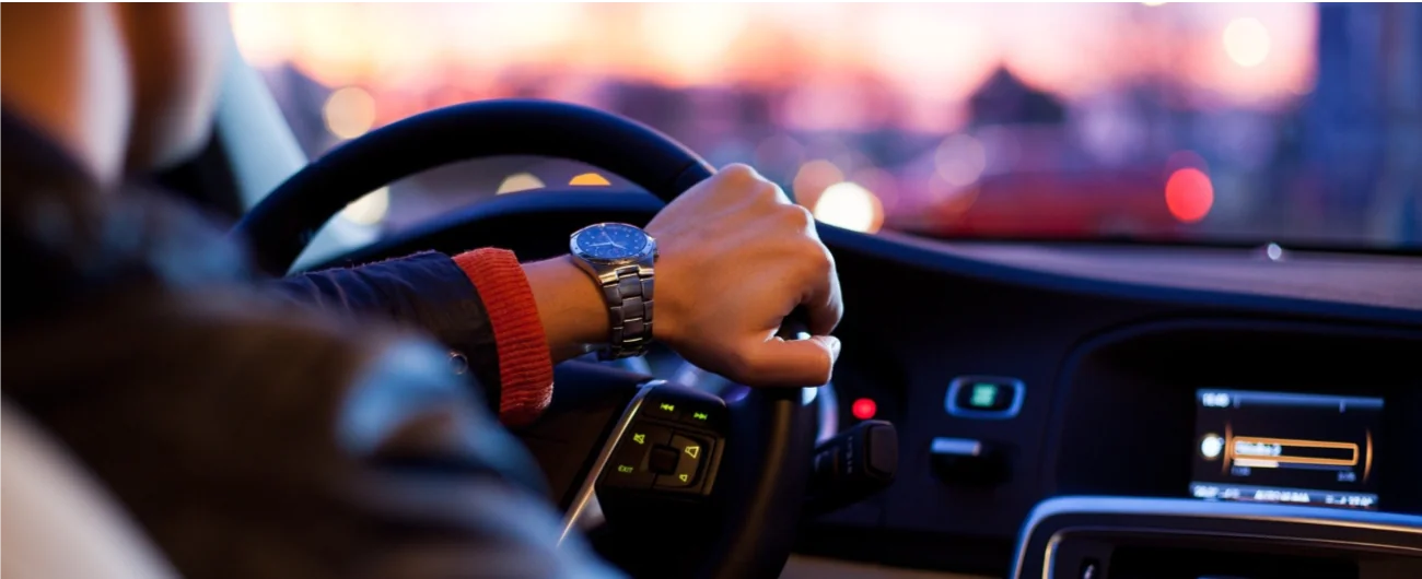 Driver behind the wheel at dusk — Massachusetts auto insurance coverage