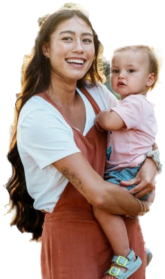 A smiling mother holding her baby outdoors